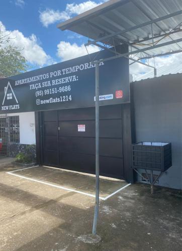 a sign in front of a building with a garage at Suíte privada com estacionamento in Boa Vista