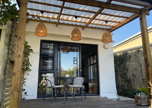a patio with a table and chairs under a pergola at Nahoon Studio B in East London