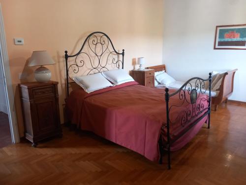 a bedroom with a large bed with a red bedspread at Le Corti - Agriturismo Olio e Vino in Lastra a Signa
