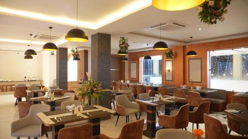a restaurant with tables and chairs in a room at Elysiumarc Hotel & Resort 