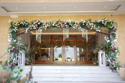 a floral arch on the front of a building with stairs at Elysiumarc Hotel & Resort 