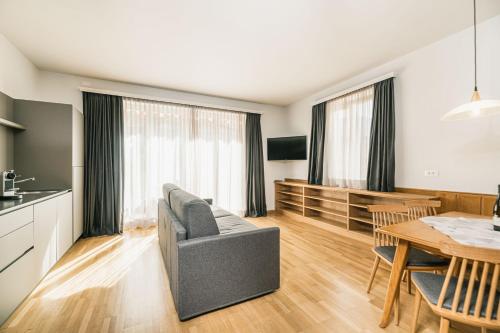 a kitchen and living room with a table and a couch at Aquila Dolomites Residence in Ortisei