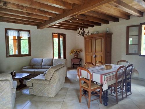 una sala de estar con una mesa y un sofá en Candéjac, en Daglan