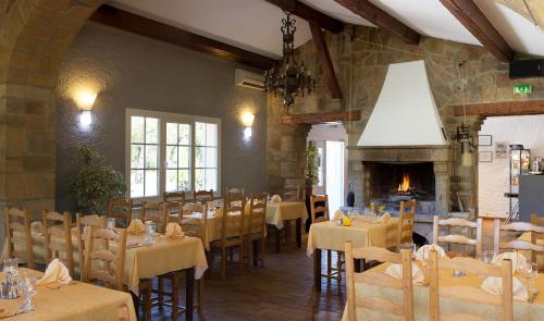 une salle à manger avec tables et chaises et une cheminée dans l'établissement Auberge du Grand Chêne, à Sillans-la-Cascade