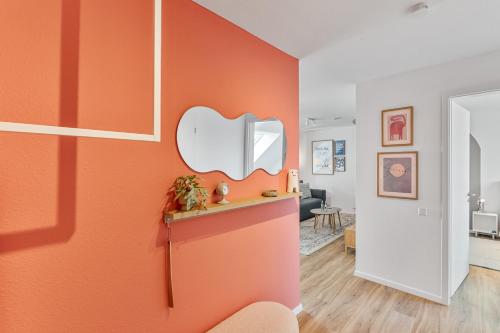 a living room with an orange accent wall at WHONAP - BLUVYN I Business I Parkplatz I Balkon I Natur in Walldürn