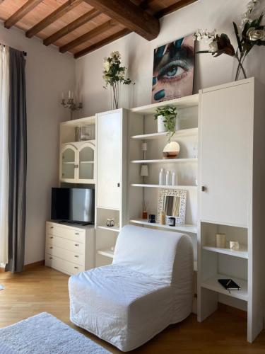 a bedroom with a bed and a white cabinet at Maison Odette in Pisa