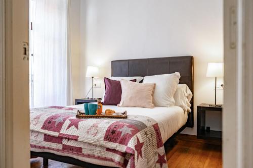 a bedroom with a bed with a blanket and two lamps at Apartamentos San Roque en Llanes by megustarural in Llanes