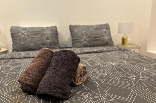 a bed with two towels on top of it at Le St Roch - Chic & Pratique in Roanne