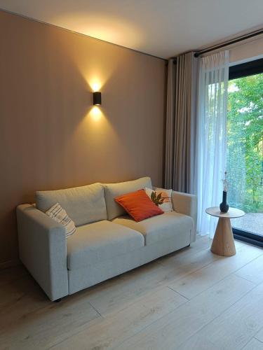 a white couch in a living room with a window at het Boekenhof in Niel
