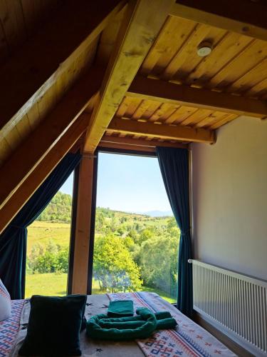 a bedroom with a bed and a large window at Cabana 3 Stejari Maramureș in Călineşti