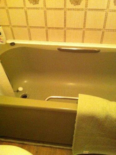 a bath tub in a bathroom with a towel at 48 Harper Road Beckton Shared in East Ham