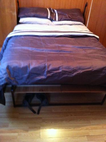 a bed with a purple comforter on top of it at 48 Harper Road Beckton Shared in East Ham