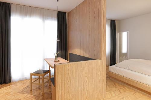 a bedroom with a bed and a desk and a bed sqor at Aquila Dolomites Residence in Ortisei