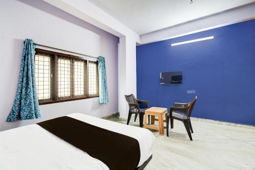 a bedroom with a bed and two chairs and a tv at Hotel O Green leaf inn in Surūrnagar