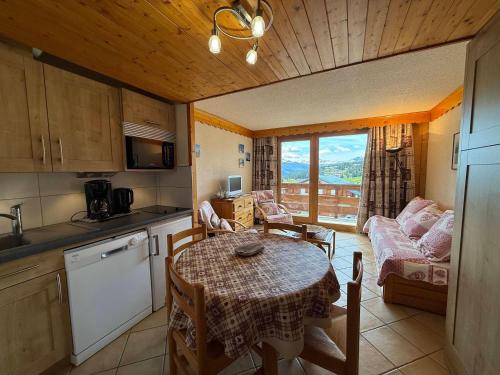 une cuisine et un salon avec une table et un canapé dans l'établissement Studio Cabine avec Balcon Sud, 4 Couchages, Equipé, Vue Pistes - FR-1-293-178, aux Saisies