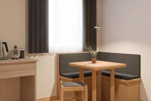 a table and a chair in a room with a table at Aquila Dolomites Residence in Ortisei