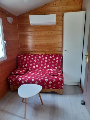 a living room with a red couch and a table at Gîtes à La Ferme Du Marquisat in Crots