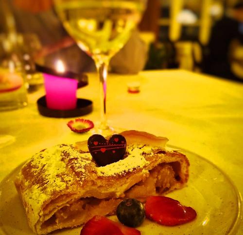 a piece of food on a plate with a wine glass at T'AMI Hotel Resort Spa in Selvino