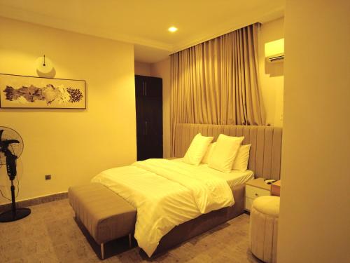Un dormitorio con una cama grande y una ventana. en Villa Soteria, en Abuja
