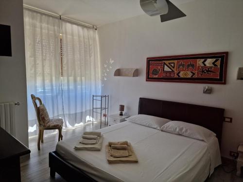 una camera da letto con un letto, una sedia e una finestra di Le Logge Apartment a Baratti