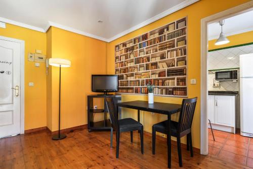 a dining room with yellow walls and a table and chairs at Apartamentos San Roque en Llanes by megustarural in Llanes