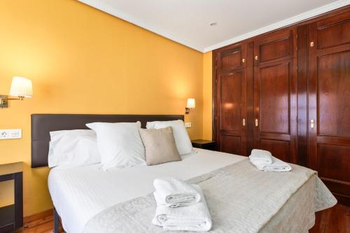 a bedroom with a bed with two towels on it at Apartamentos San Roque en Llanes by megustarural in Llanes