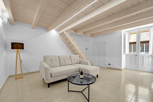a living room with a white couch and a table at Alloggio incantevole Specchia al centro in Specchia