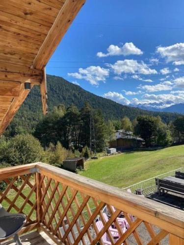 a deck with a view of a field and mountains at The Alpine No 7 in Reith bei Seefeld