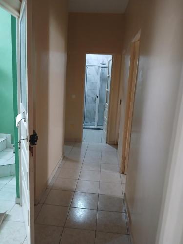an empty hallway with a tile floor and a door at Mar&Cruz in Mindelo