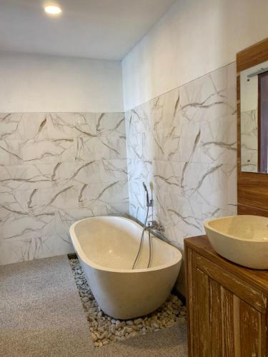 a bathroom with a tub and a sink at Dukuh Sari Villa in Ubud