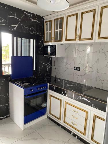 a kitchen with a black and white counter top at Aloha Suites Odza - by Skyline Residence Services in Yaoundé
