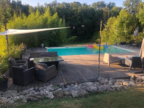 une terrasse avec des chaises et une table, ainsi qu'une piscine dans l'établissement Pause campagnarde, à Saint-Jean-le-Comtal