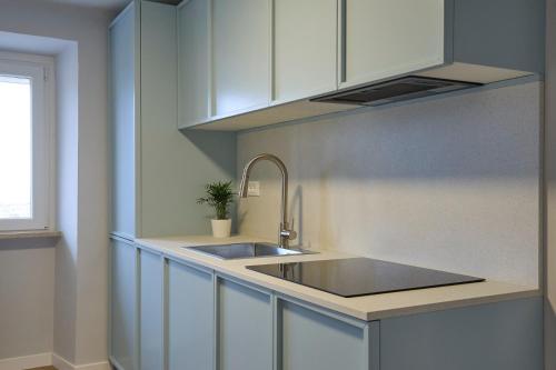 a kitchen with a sink and white cabinets at CAMERANOAPARTMENTS - Sopra la Piazza in Camerano