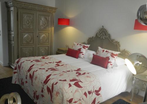 Un dormitorio con una cama grande con almohadas rojas. en Villa Toscane, en Marciac