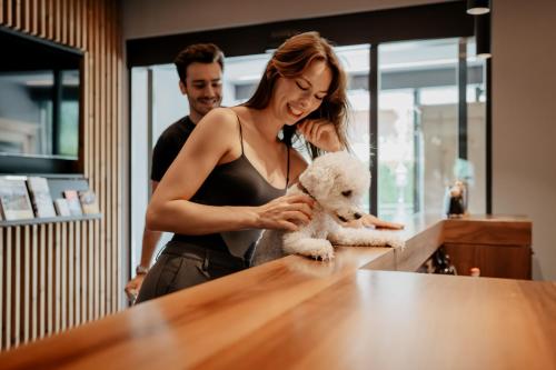 a woman holding a teddy bear at a counter at Hotel Bergzeit in Grossarl