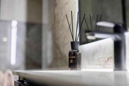 a bottle with sticks in it sitting on a table at Falco Boutique Home with Jacuzzi in Naples