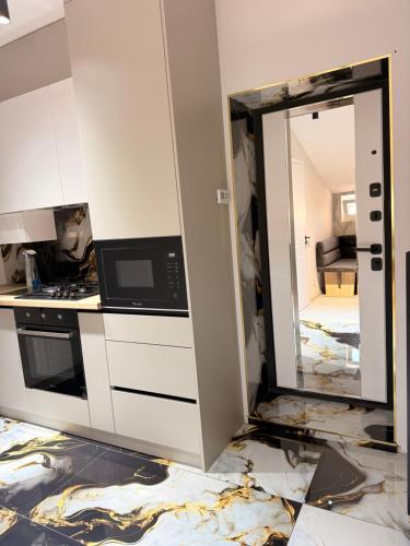 a kitchen being remodeled with a microwave and a mirror at Apartament studio in Durleşti