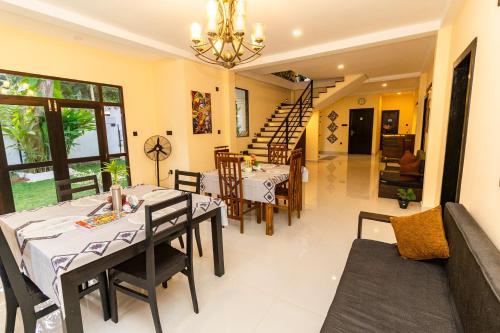 a dining room with tables and chairs and a staircase at Heaven Breeze Hotel Ahangama in Ahangama