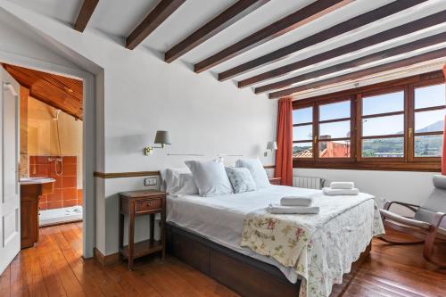 a bedroom with a large bed and a window at Apartamentos San Roque en Llanes by megustarural in Llanes
