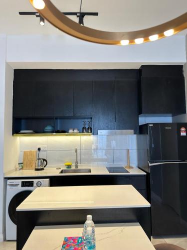 a kitchen with black cabinets and a counter top at Axon Residence KL Pavilion in Kuala Lumpur