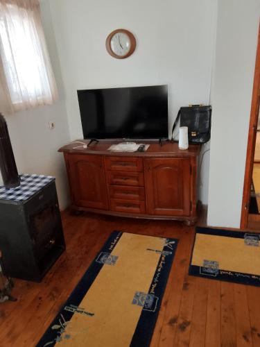 a living room with a tv and a wood stove at Rest House Tara in Mojkovac