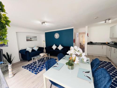 a living room with a table and a blue wall at The Barbican Apartments in Plymouth