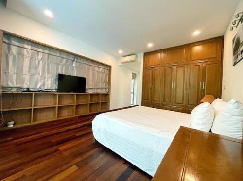 a bedroom with a bed and a flat screen tv at Flamigo Dai Lai Resort - Happy Villa in Ngọc Quang