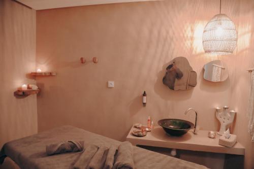a bedroom with a bed and a sink and a lamp at White Dune Canyon in Dakhla