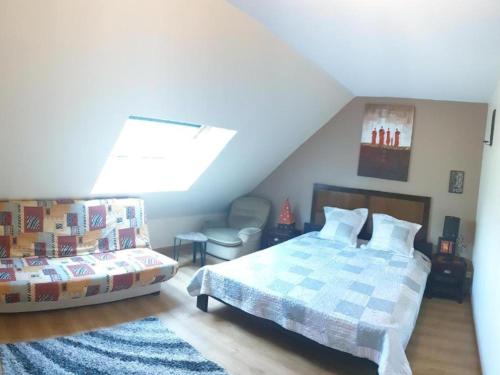 a bedroom with a bed and a chair in a attic at Suite 2Chambres salle de bain privés toilettes Terrasse Parking 30 min de Paris in Corbeil-Essonnes