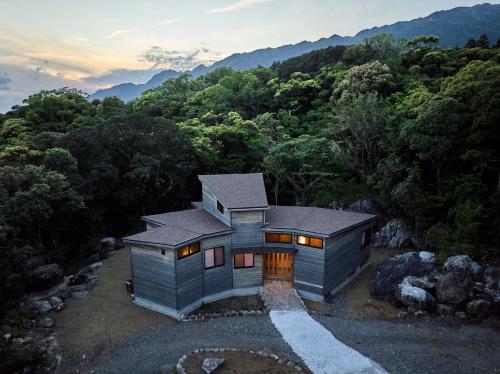 an aerial view of a house in the woods at 日照雨 SOBAE Stream Villa YAKUSHIMA Private villa on the river in the primeval forest in Yudomari