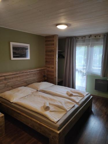 a large bed in a room with a window at Penzion Kovářov in Frymburk