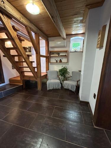 a living room with two chairs and a wooden ceiling at Chalupa Ořechov in OÅ™echov