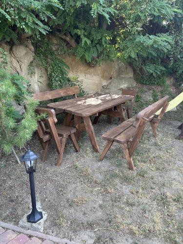 a wooden picnic table and a bench in the grass at Chalupa Ořechov in OÅ™echov