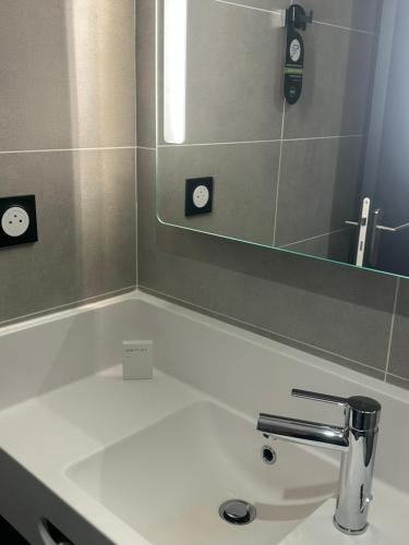 a bathroom with a sink and a mirror at B&B HOTEL PERPIGNAN Nord Aéroport in Perpignan
